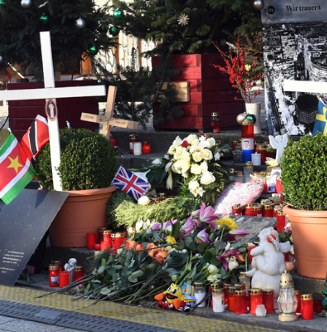 Blumen erinnern am 18.12.2017 in Berlin auf dem Weihnachtsmarkt am Berliner Breitscheidplatz an den Anschlag. Bei dem Anschlag mit einem Lastwagen tötete ein islamistischer Terrorist am 19. Dezember vergangenen Jahres 12 Menschen und verletzte etwa 70. Foto: Maurizio Gambarini/dpa