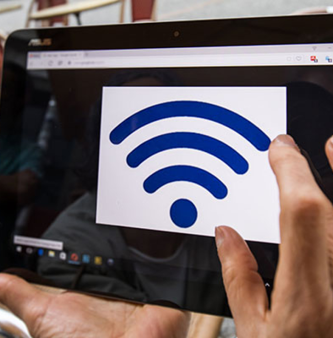 WLAN-Logo wird in einem Café auf dem Bildschirm eines Tablet-Computers angezeigt.