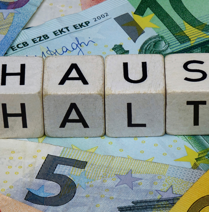 Buchstabenwürfel "Haushalt" auf Geldscheinen