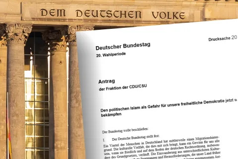 Reichstag im Hintergrund mit der Aufschrift "Dem Deutschen Volker". Im Vordergrund der Antrag der Fraktion der CDU/CSU zur Bekämpfung des politischen Islams
