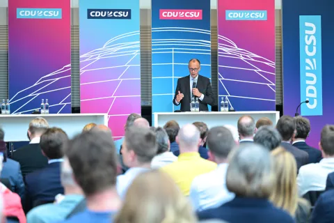 Kirchenkongress der CDU/CSU Fraktion. Friedrich Merz spricht am Rednerpult. Im Vordergrund das Publikum des Kongresses in der Rückansicht.
