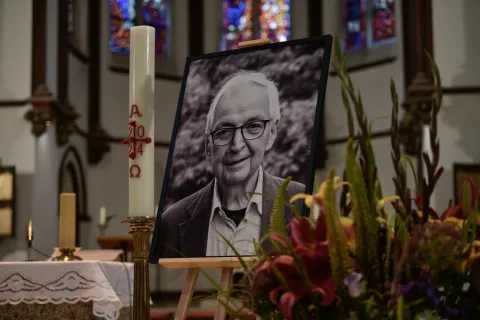 S/W-Foto von Klaus Töpfer auf einer Staffelei in der Kirche bei der Trauerfeier der Unionsfraktion. Daneben stehen eine Kerze und Blumen.