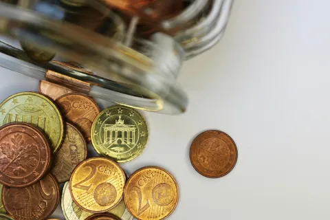 Euro-Münzen liegen vor einem Glas