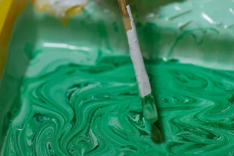 Grüne Farbe und Pinsel als Symbol für Greenwashing