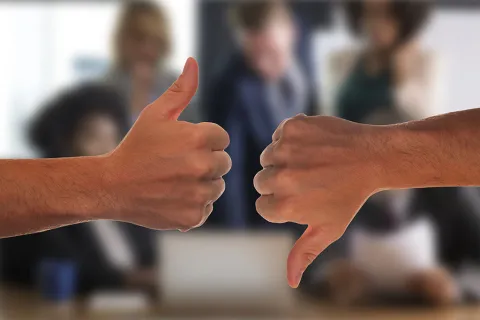 zwei Hände - einmal mit Daumen hoch, einmal mit Daumen runter