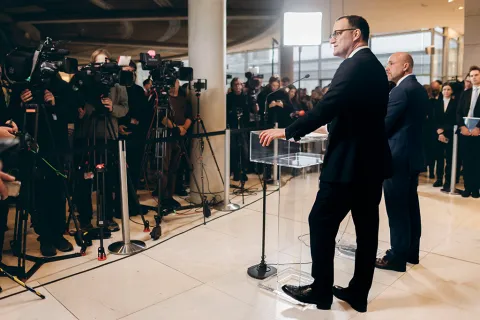 Jens Spahn und Alexander Hoffmann stehen an Rednerpulten, vor ihnen ist eine Gruppe von Videojournalisten.