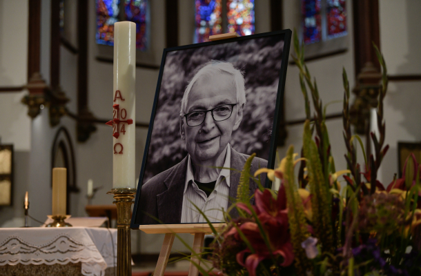 S/W-Foto von Klaus Töpfer auf einer Staffelei in der Kirche bei der Trauerfeier der Unionsfraktion. Daneben stehen eine Kerze und Blumen.