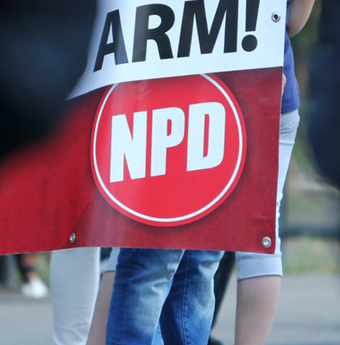 Rechtsextreme demonstrieren in Trier (Rheinland-Pfalz) und halten dabei ein Schild unter anderem mit der Aufschrift «Arm! / NPD» hoch. 