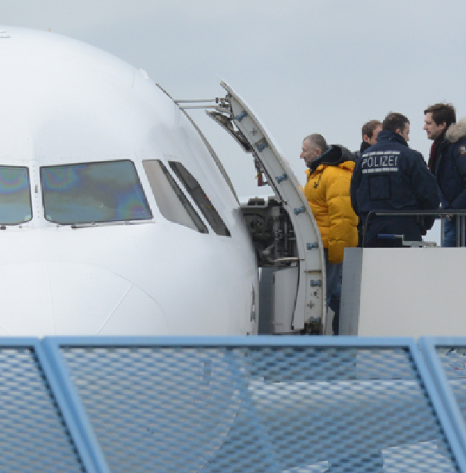 Abgelehnte Asylbewerber besteigen ein Flugzeug