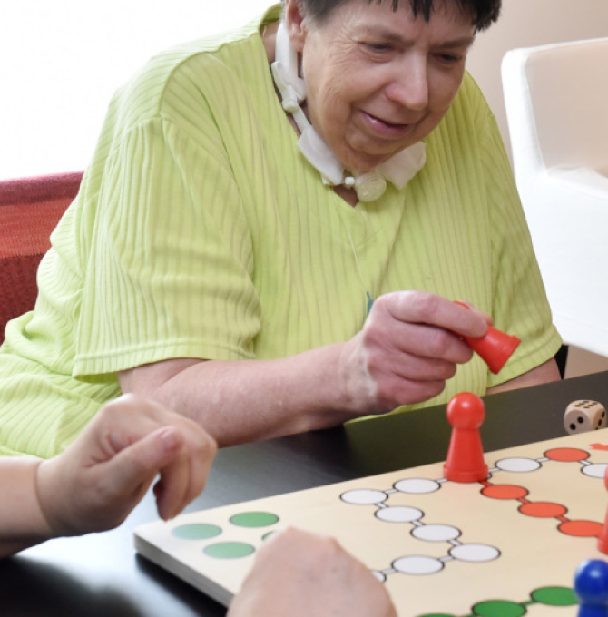 Altenpflegerin mit Intensiverfahrung spielt mit Patientin
